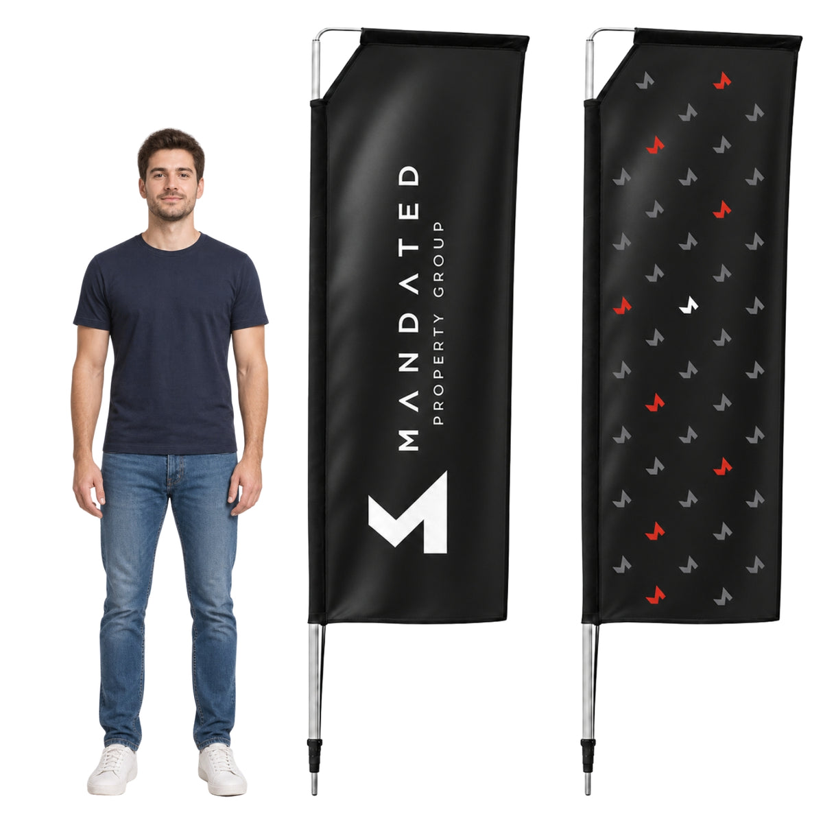 A man wearing a navy blue t-shirt and jeans stands next to two custom black vertical flag banners on a white background. One banner features the white text 'MANDATED PROPERTY GROUP' with a white geometric logo, and the other shows a repeating pattern of small red, gray, and white logos.
